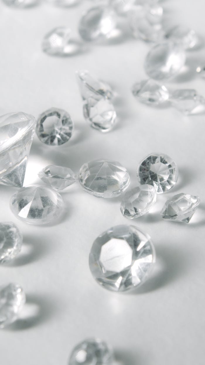 A close-up of various clear-cut gemstones on a white surface, showcasing their sparkle and clarity.